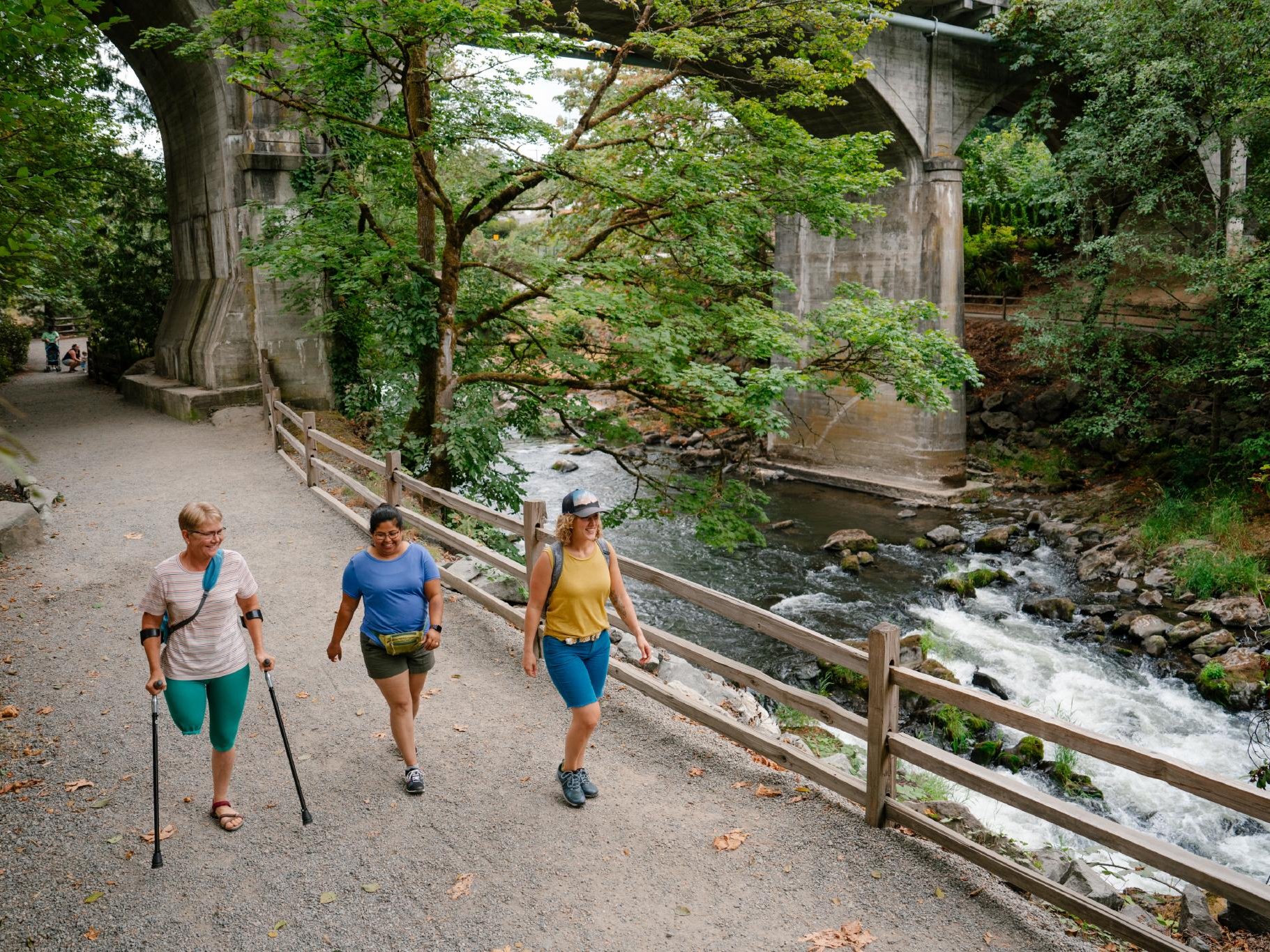 Friends walking along a path in Brewery Park at Tumwater Falls